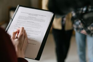 Un couple examine des documents immobiliers à l'intérieur en se concentrant sur l'écriture et la discussion.