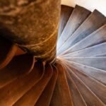Vue du dessous d'un escalier en bois tournant autour d'une colonne