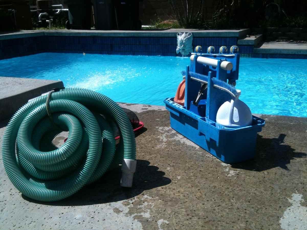 Matériel de nettoyage de piscine sur un sol en béton Matériel de nettoyage de piscine sur un sol en béton
